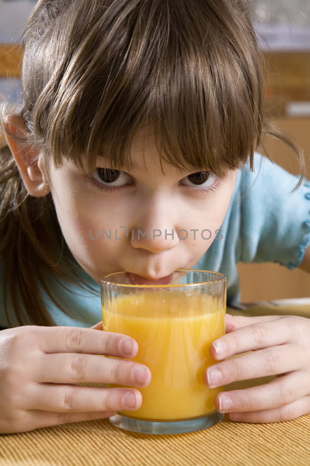  adorable serious girl seven years old drink orange juice by elenarostunova