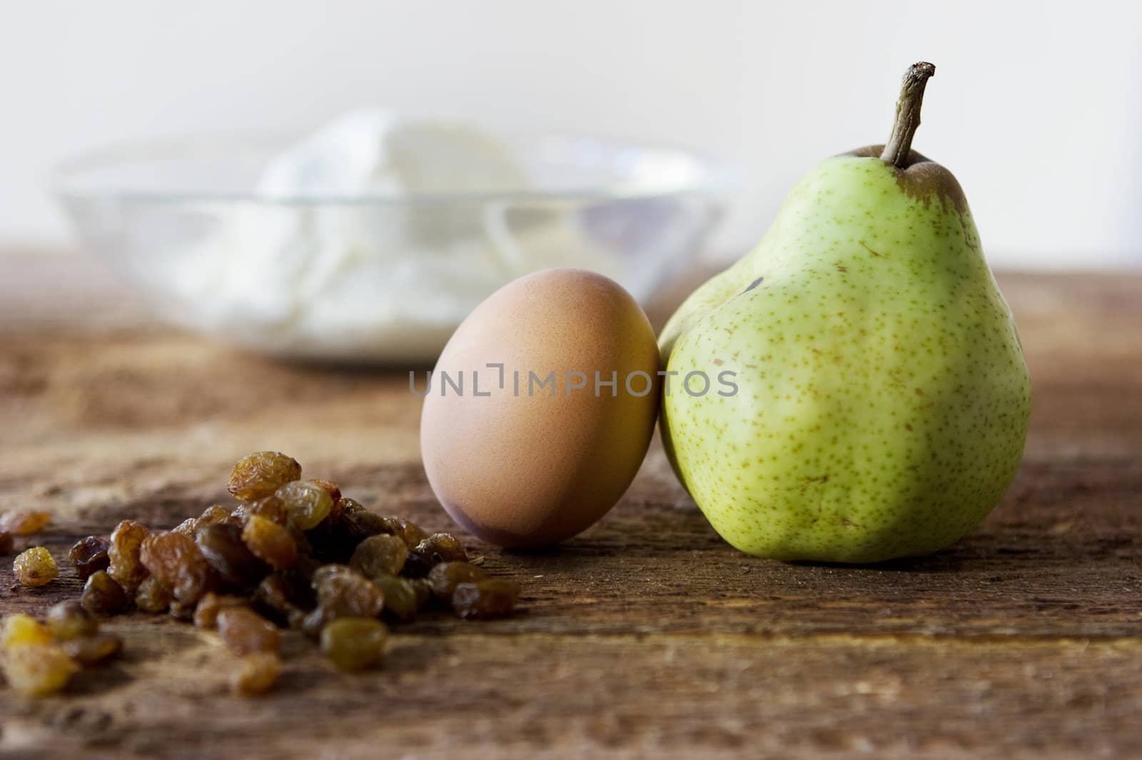 Pear, eggs, rasins and cheese in plate on the table by elenarostunova