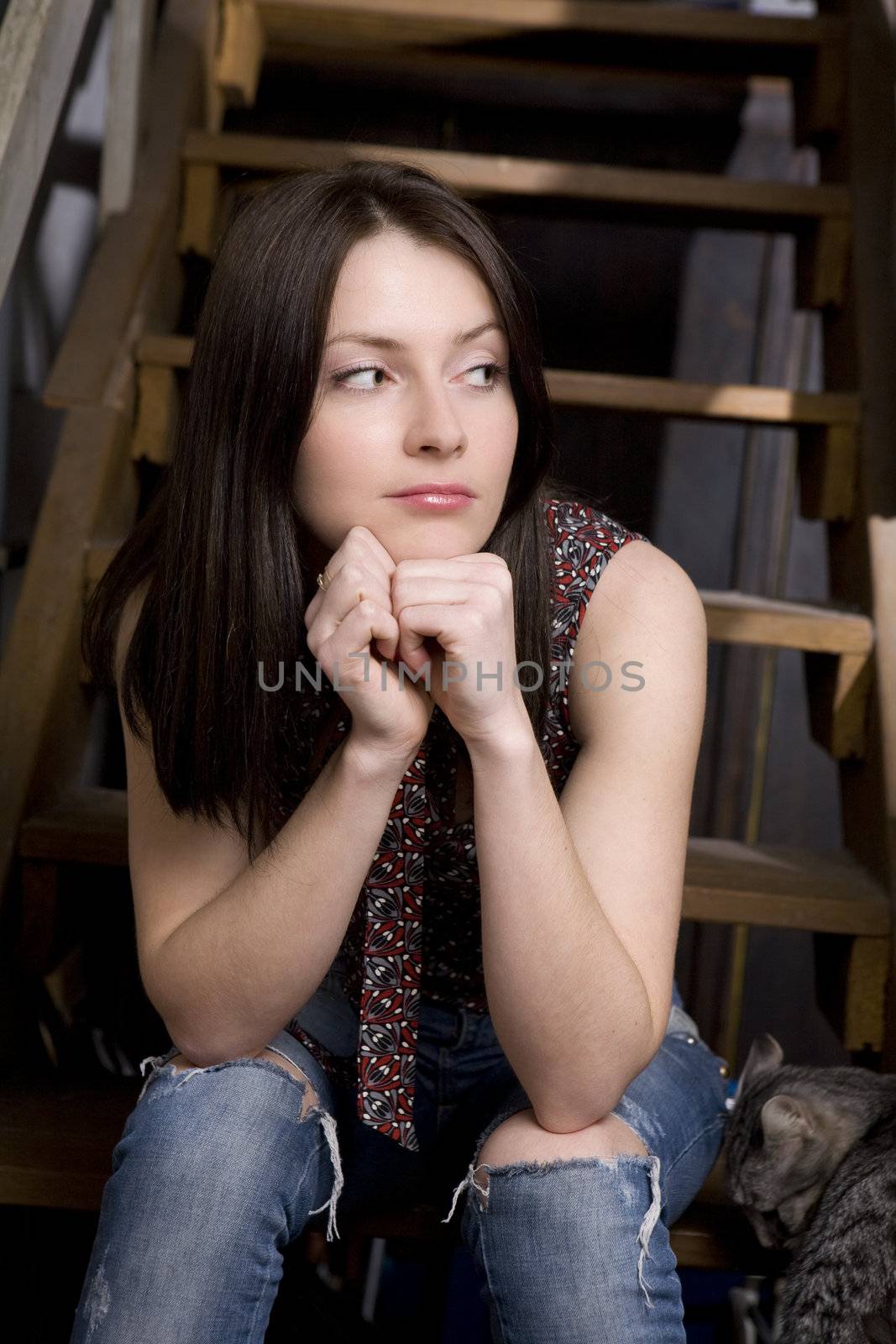 young attractive serious girl sitting on stairs