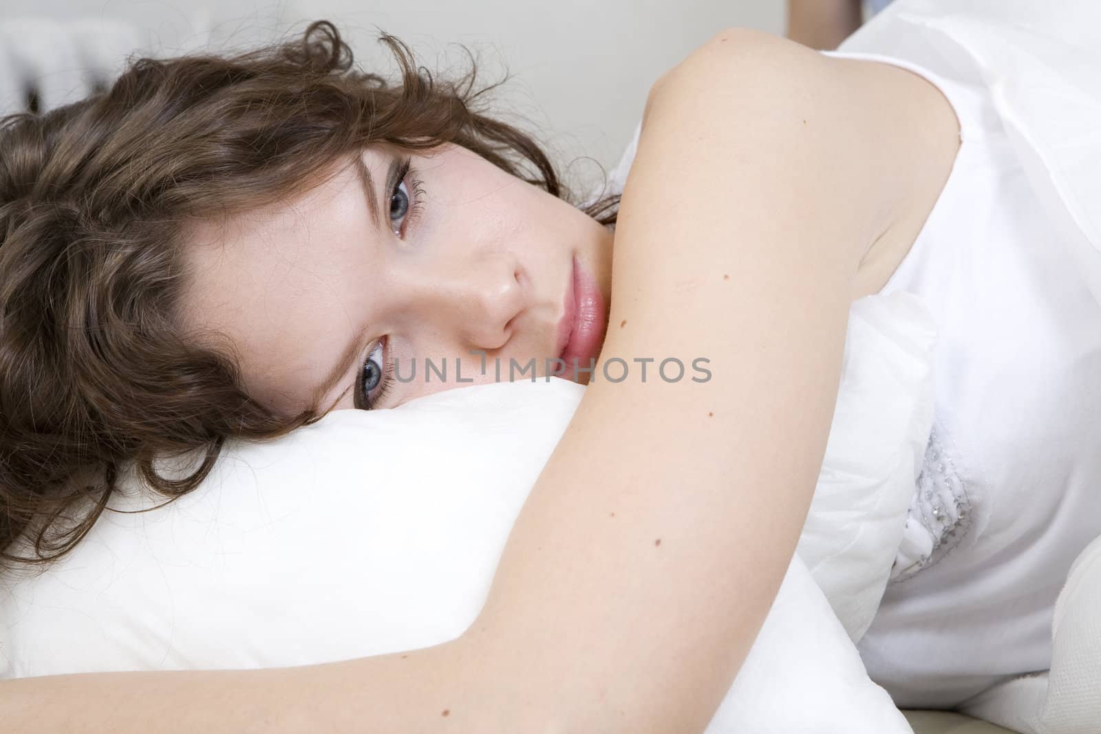 attractive thoughtful brunette curl woman lying on the bed