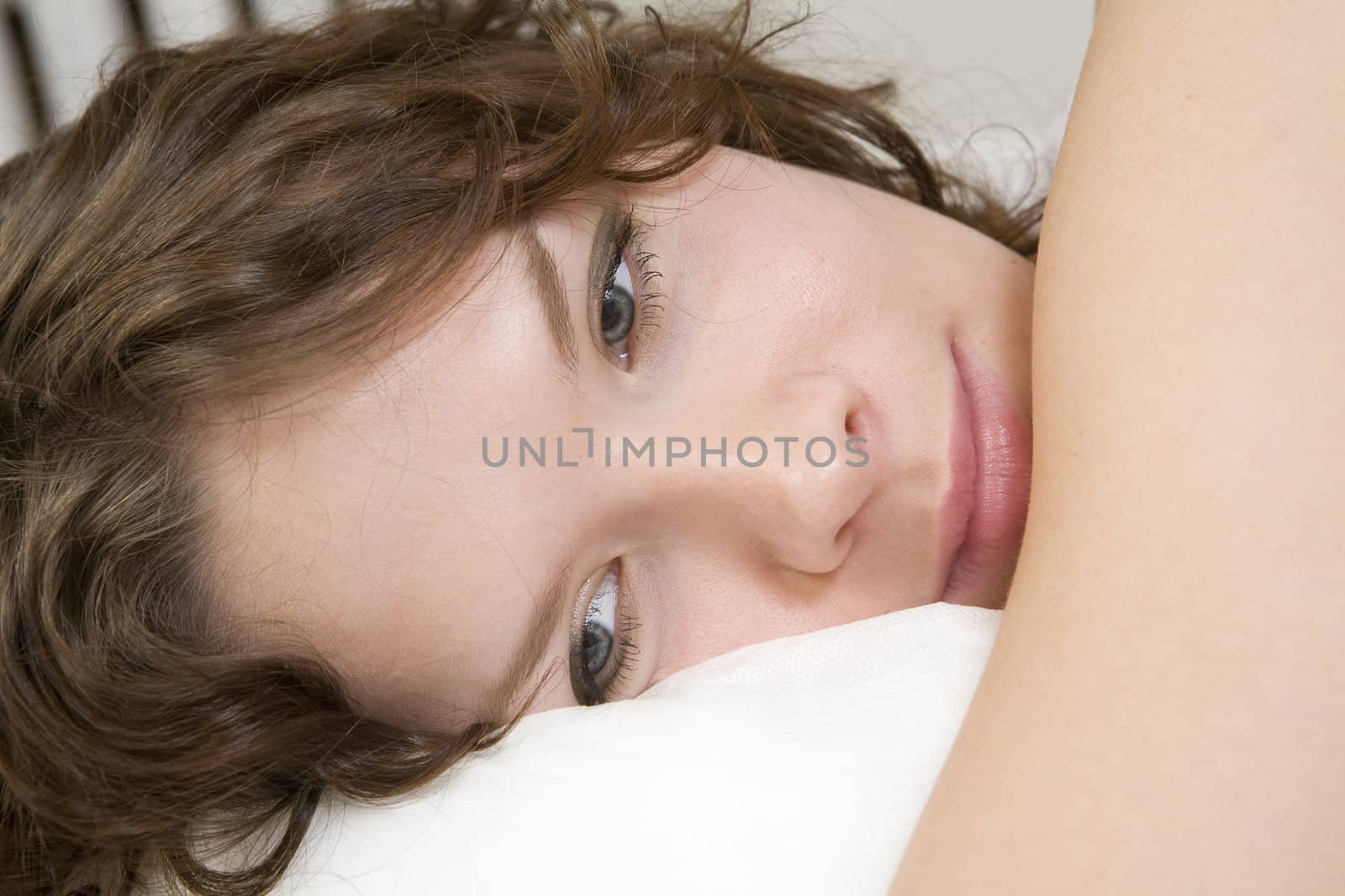 attractive thoughtful brunette curl woman lying on the bed