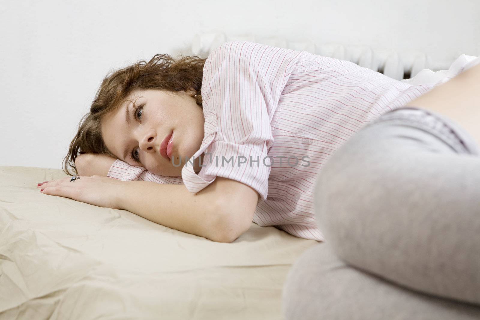 attractive thoughtful brunette curl woman lying on the bed