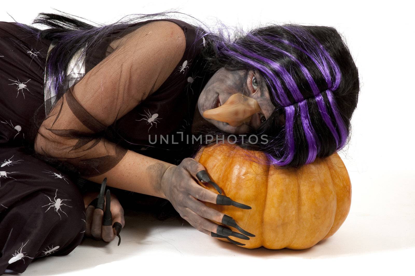 girl dressed up as a witch sleeping on a pumpkin by ladyminnie