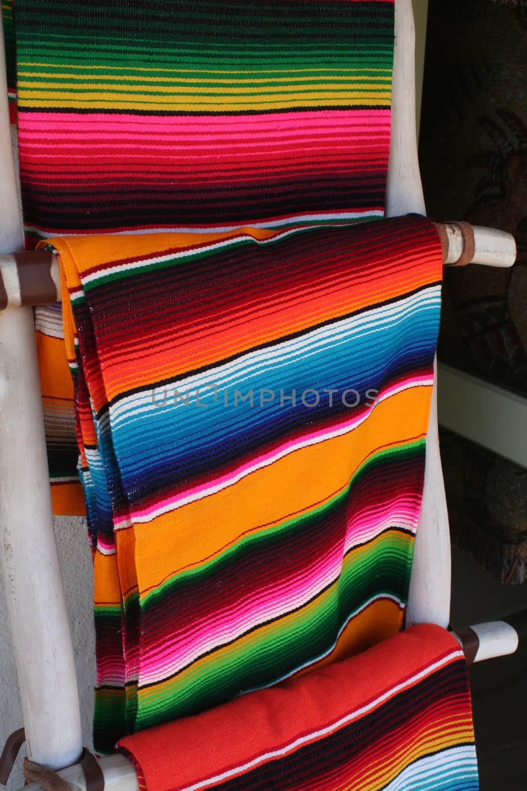 Several colorful Mexican wool blankets hung on display.
