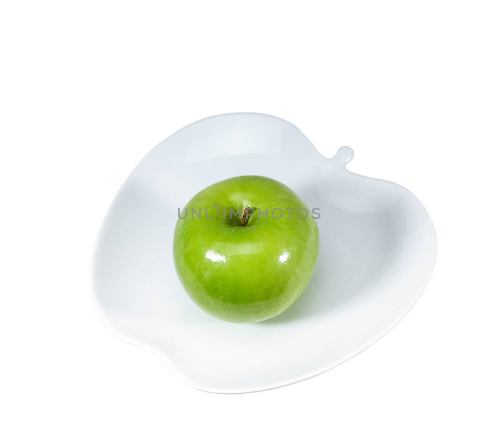 green apple on a apple shaped dish isolated over white