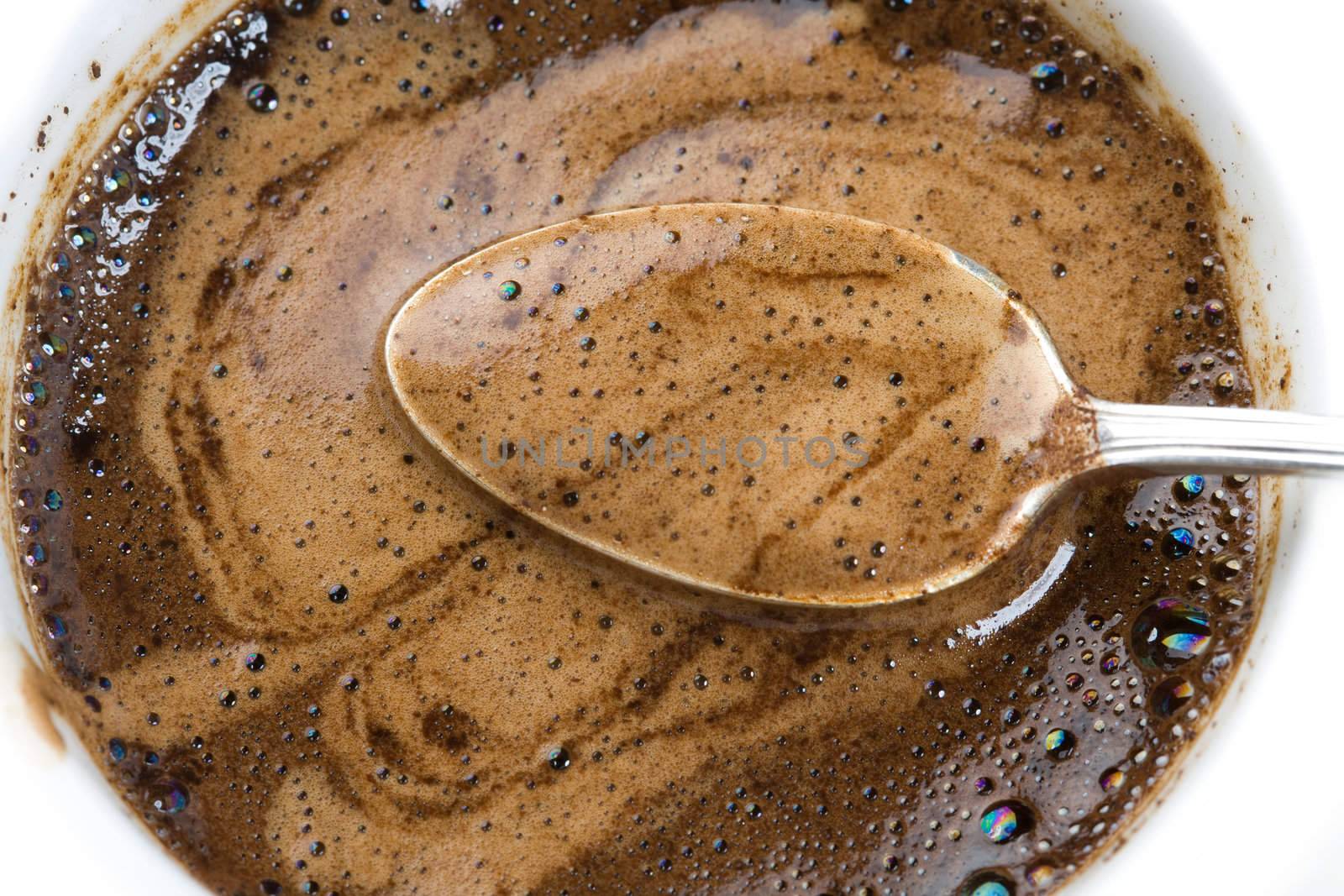 Teaspoon in a thick foam of ground coffee 