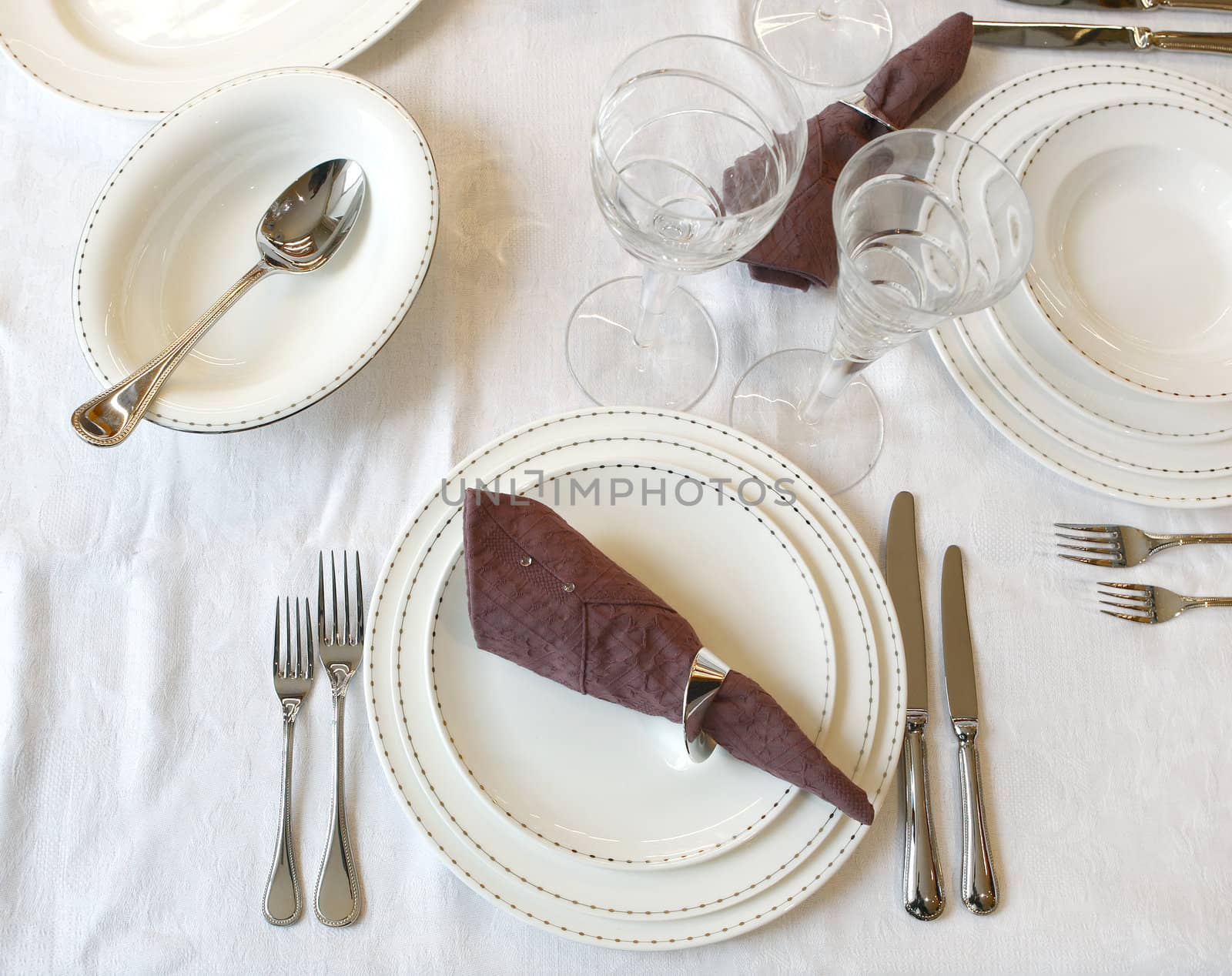 Knife, fork, spoon, plate and glasses on a table