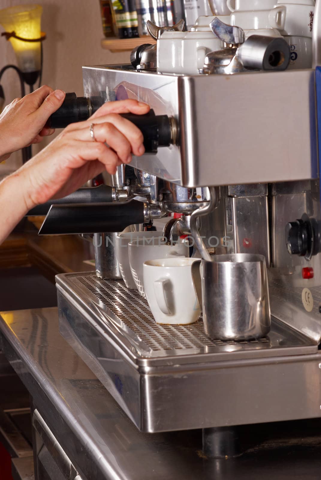 Barman operating an italian espresso machine inside a bar