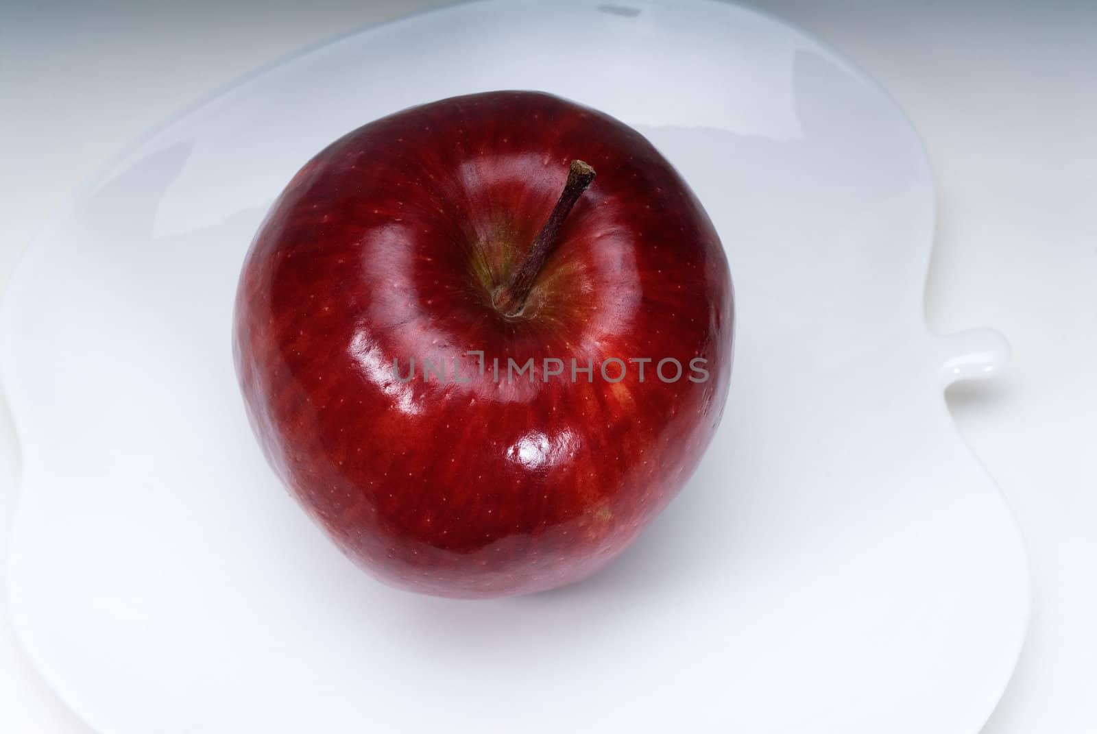 red apple on a apple shaped dish isolated over white