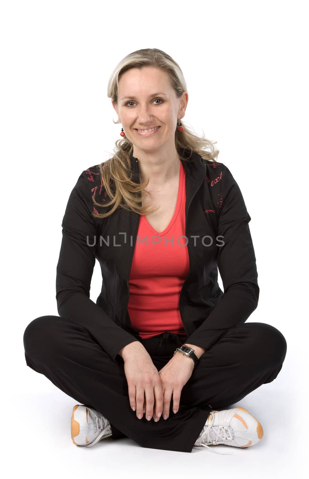 Young women with sportswear sitt on the floor. White background