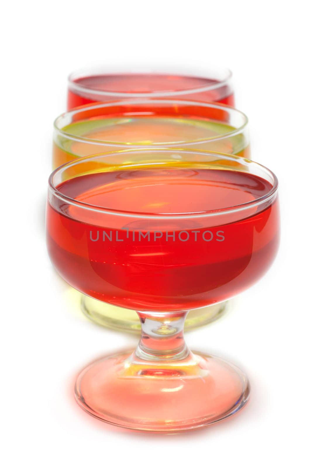 Yellow, red jelly in transparent glass stand on white background inline