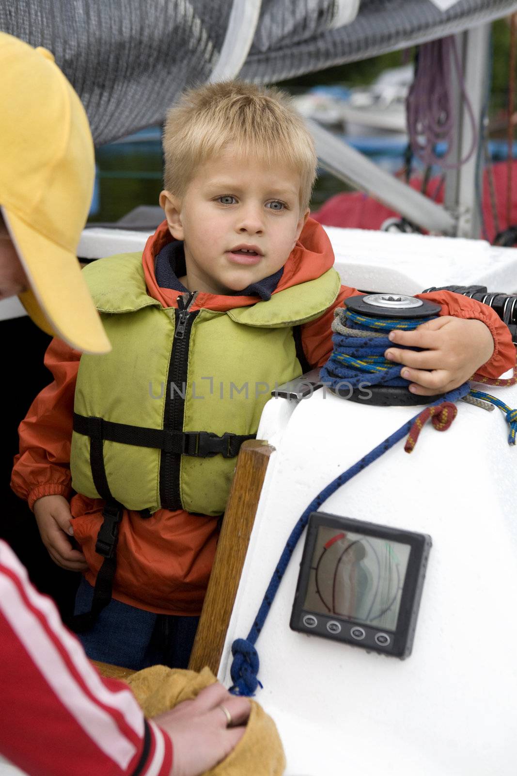 Little cute boy  in life jacket on yacht.  by elenarostunova