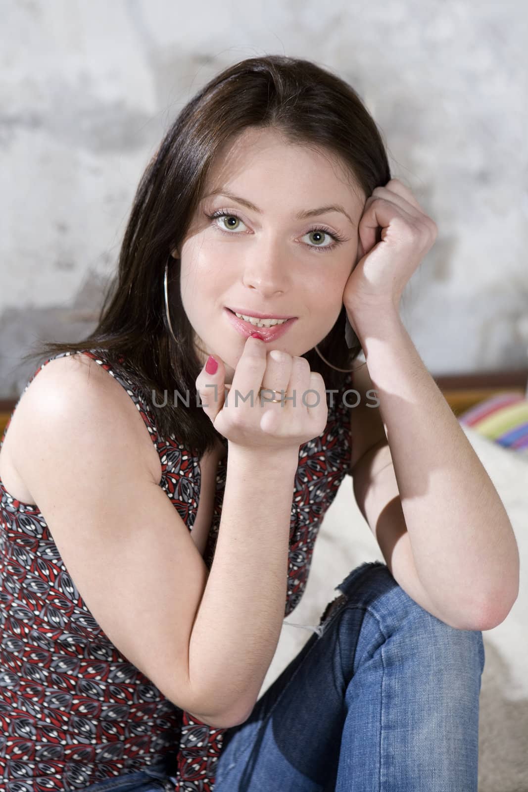 portrait young pensive attractive woman in jeans sitting on bed by elenarostunova