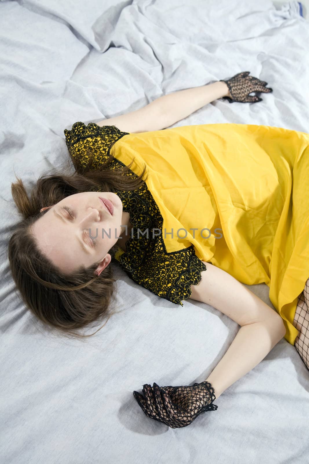 cute woman in yellow dress lying on bed by elenarostunova