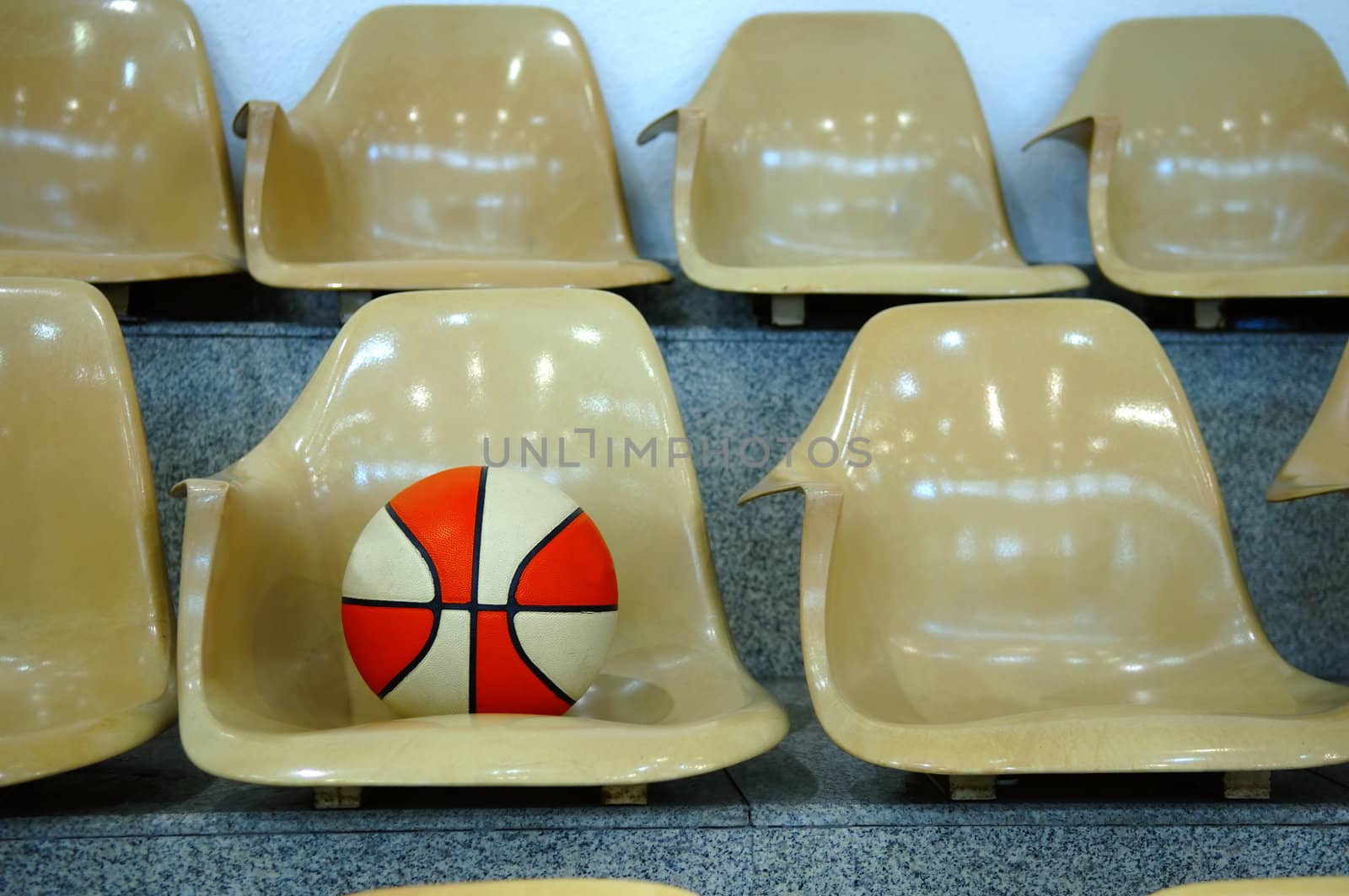 Line of stadium chairs with a basketball