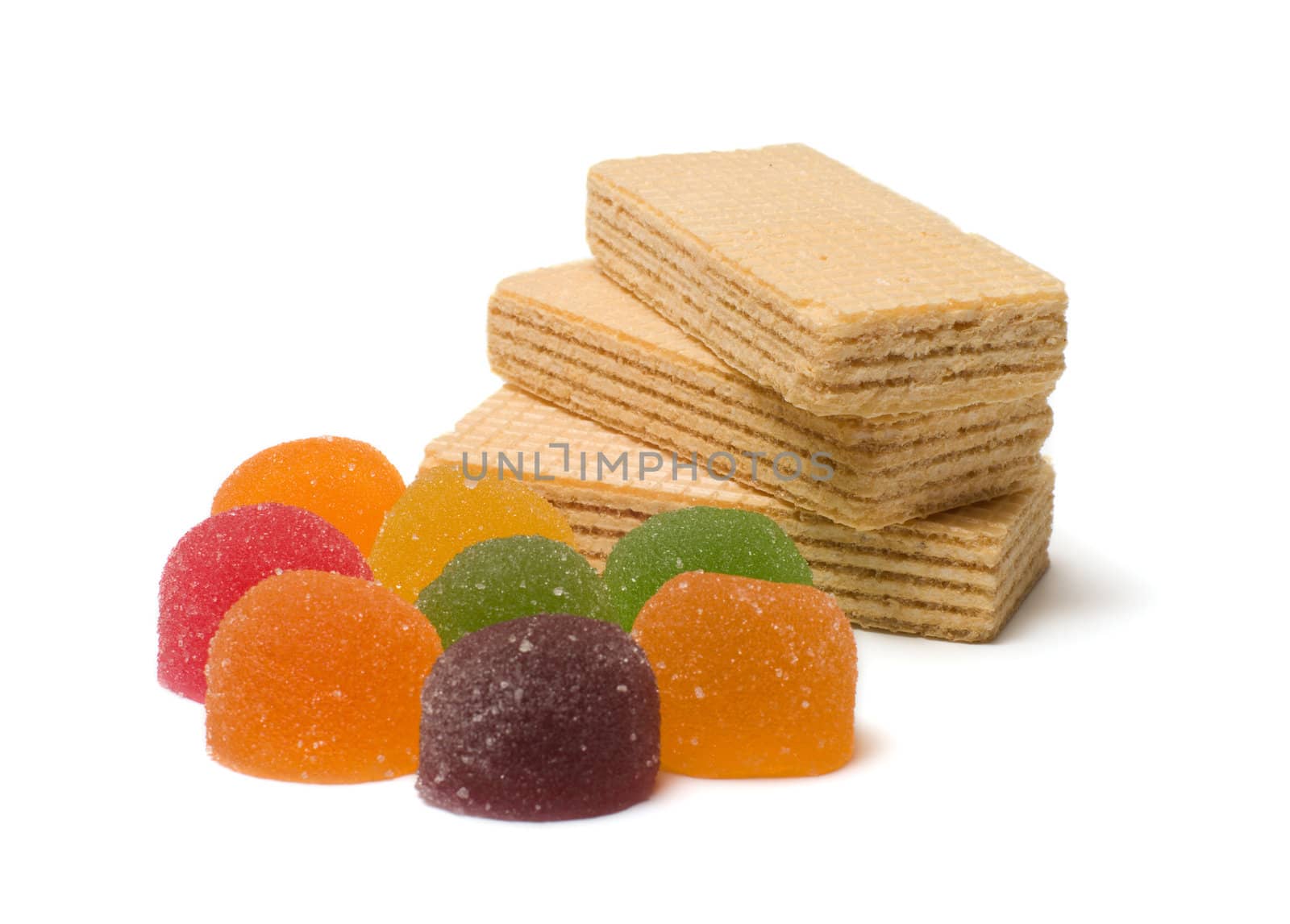 Multi-colored fruit candy and wafers on a white background.