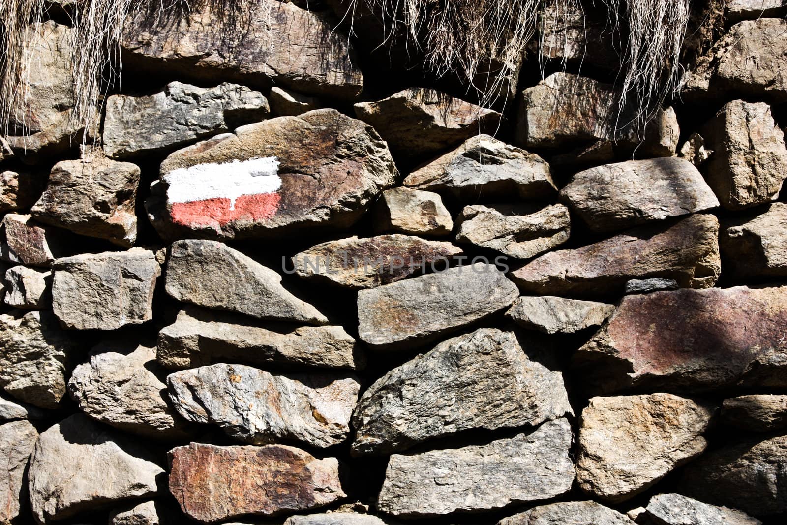 Stonewall with the sign of the mountain path, good for conceptual