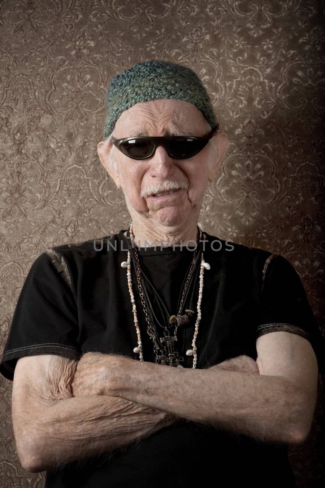 Senior tough guy in knit cap leaning against a wall