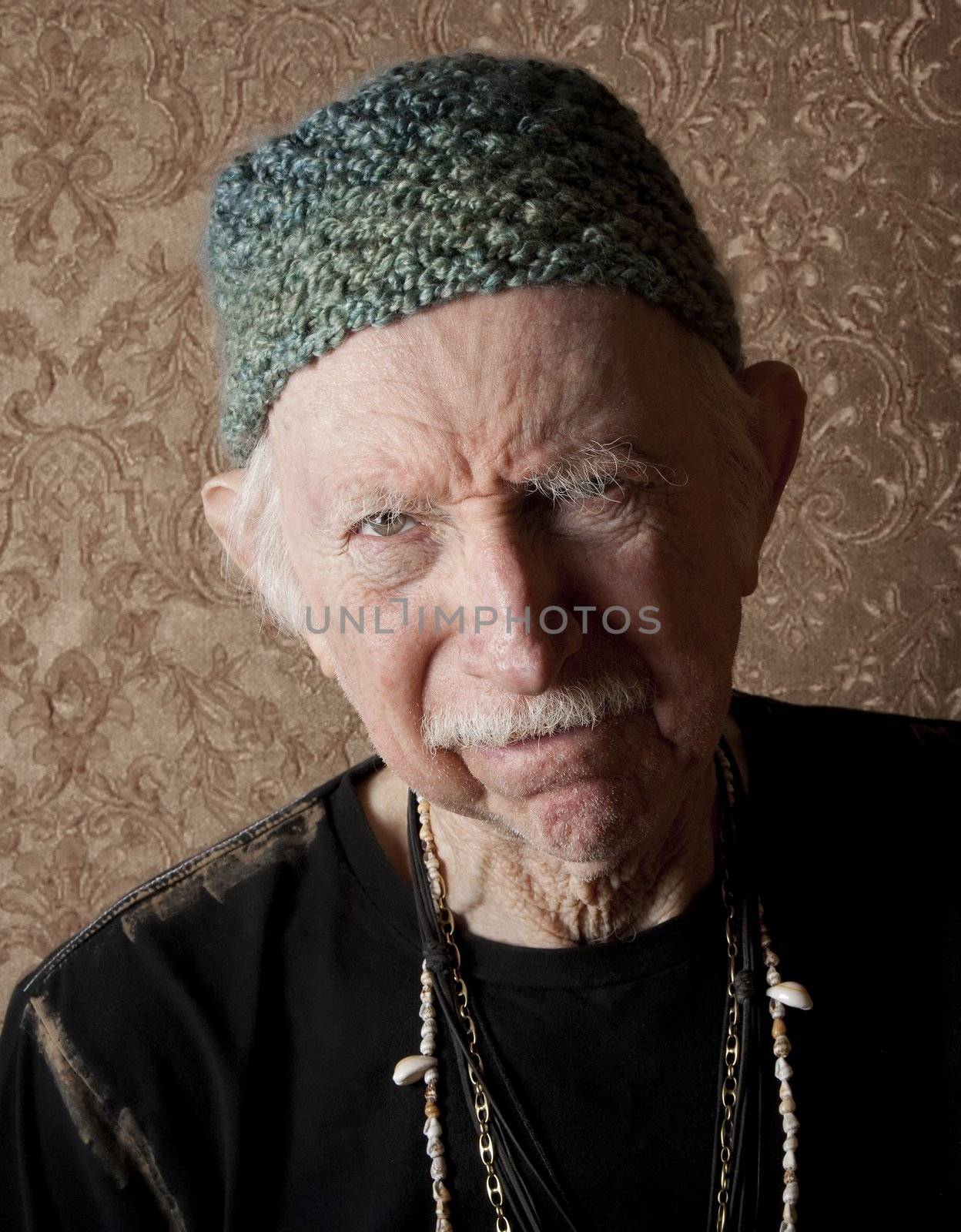 Senior tough guy in green knit cap leaning