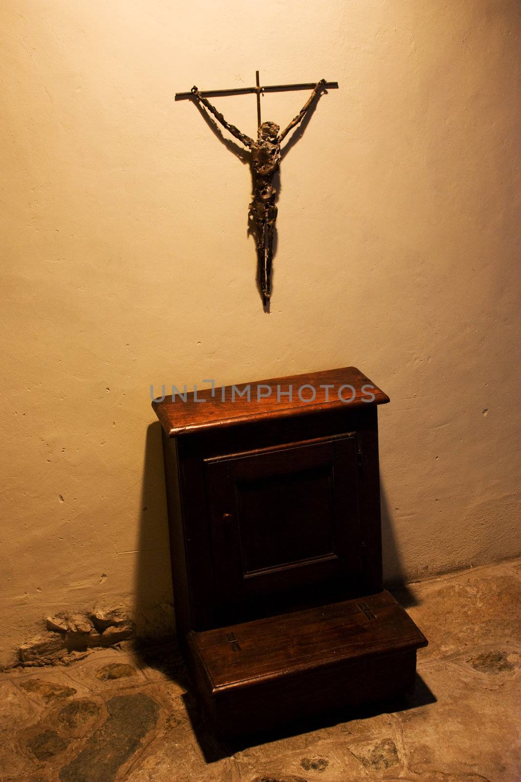 Old crucifix with faldstool in a catholic abbey