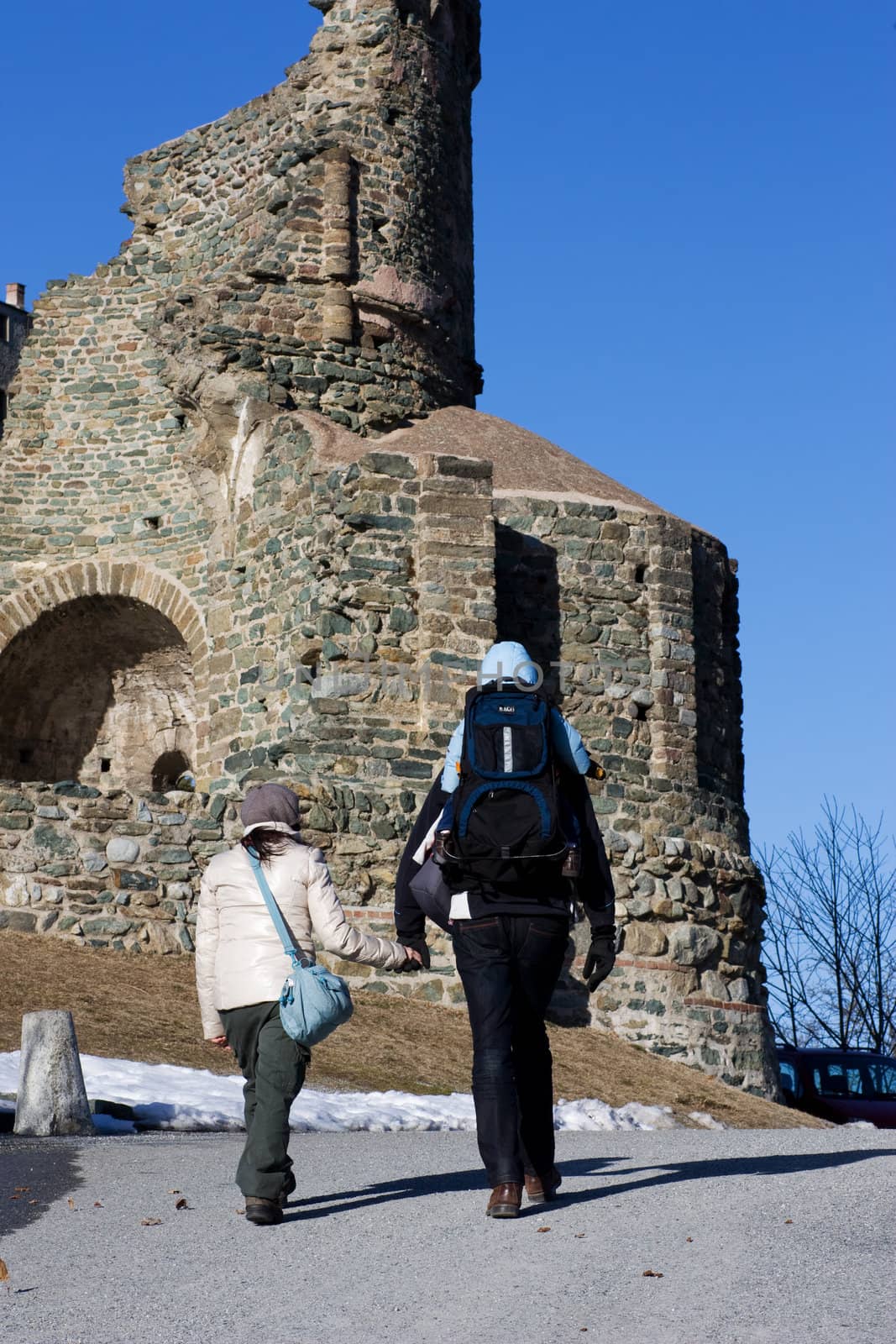 A family is walking for exercise close to an old monastery