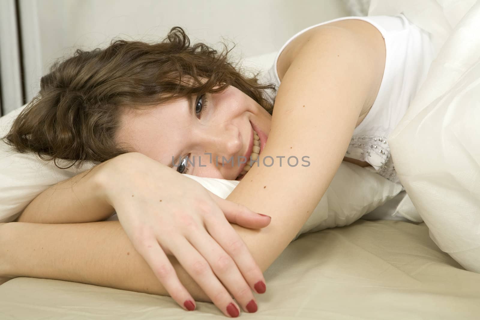 smiling curl adorable woman lying on bed
