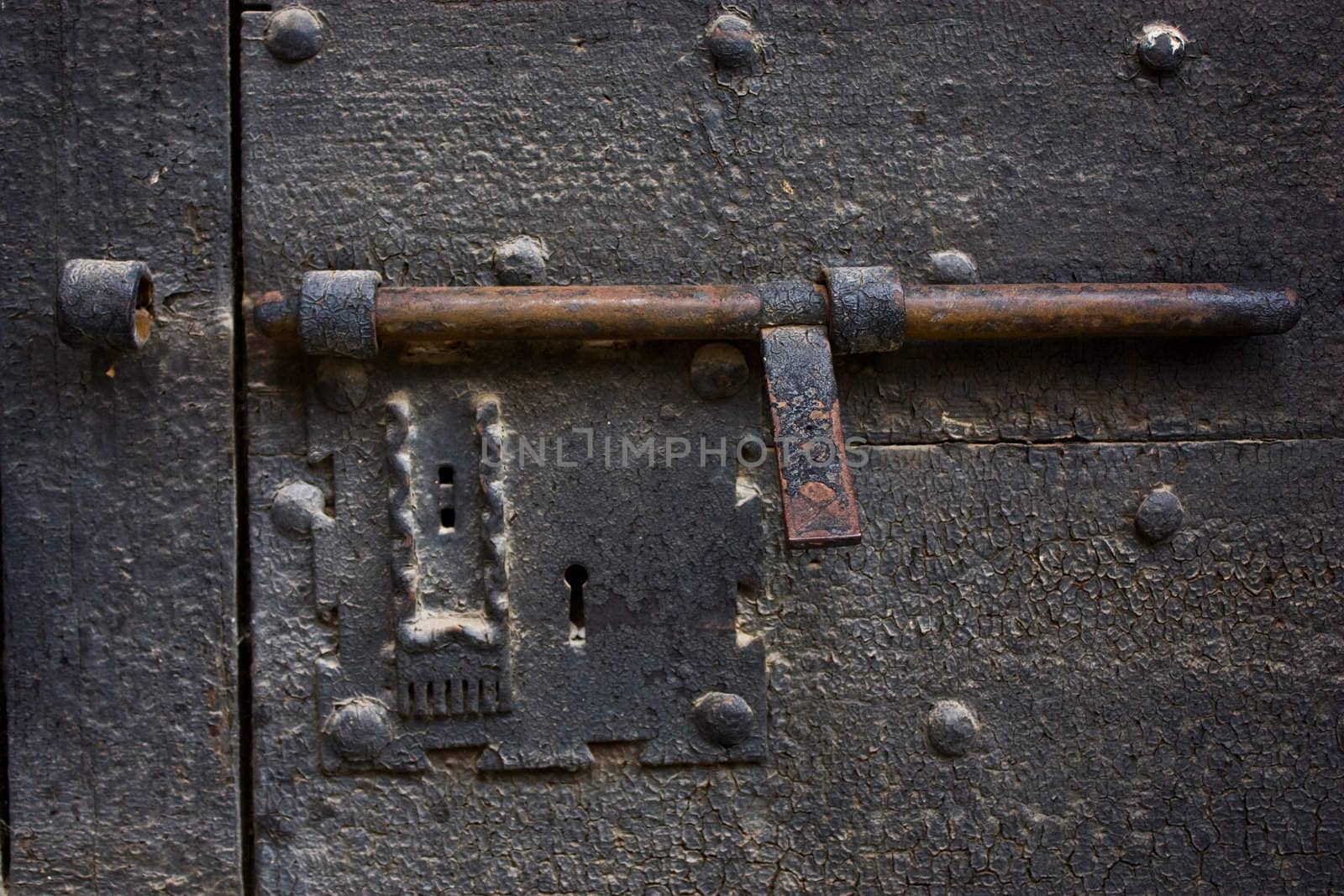 Ancient lock made of metal on a medieval door