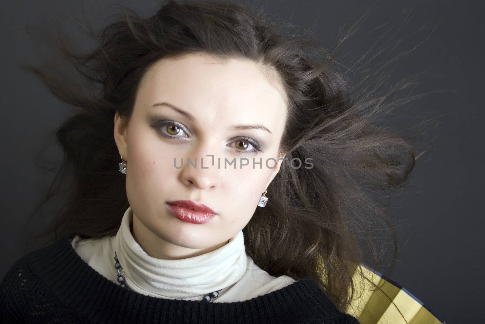 Portrait of a young beautiful brunette with the hair blowing about