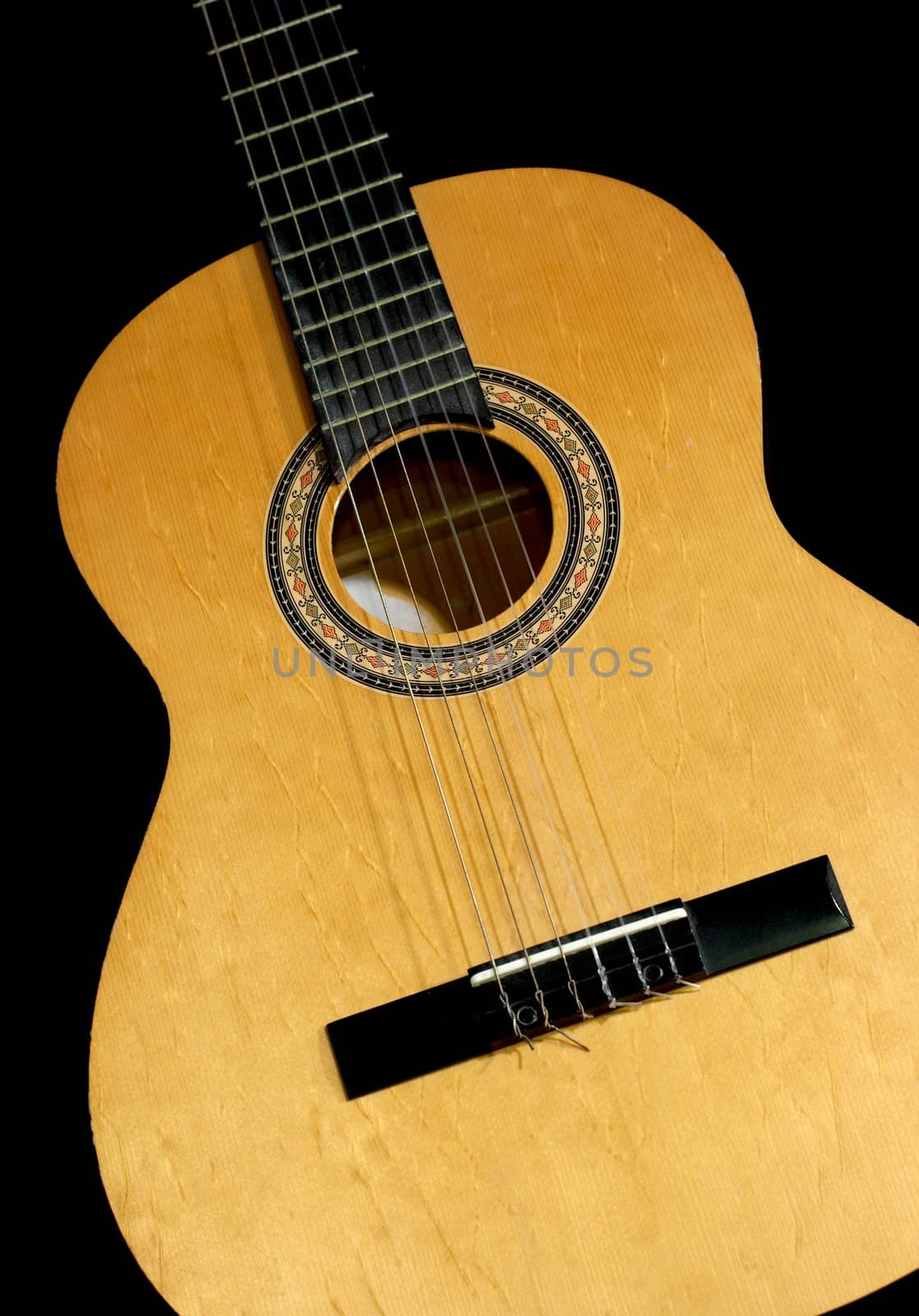 Neck and head of an acoustic guitar, isolated black background with copy-space