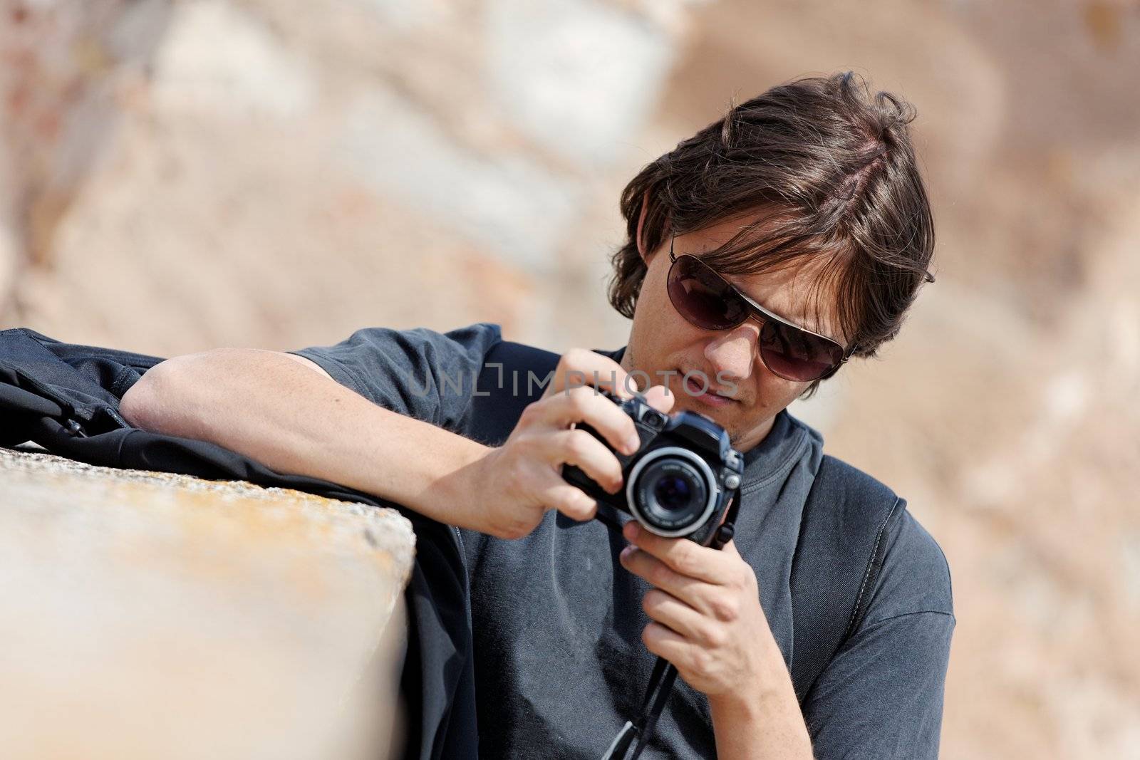 Young traveling man taking photos