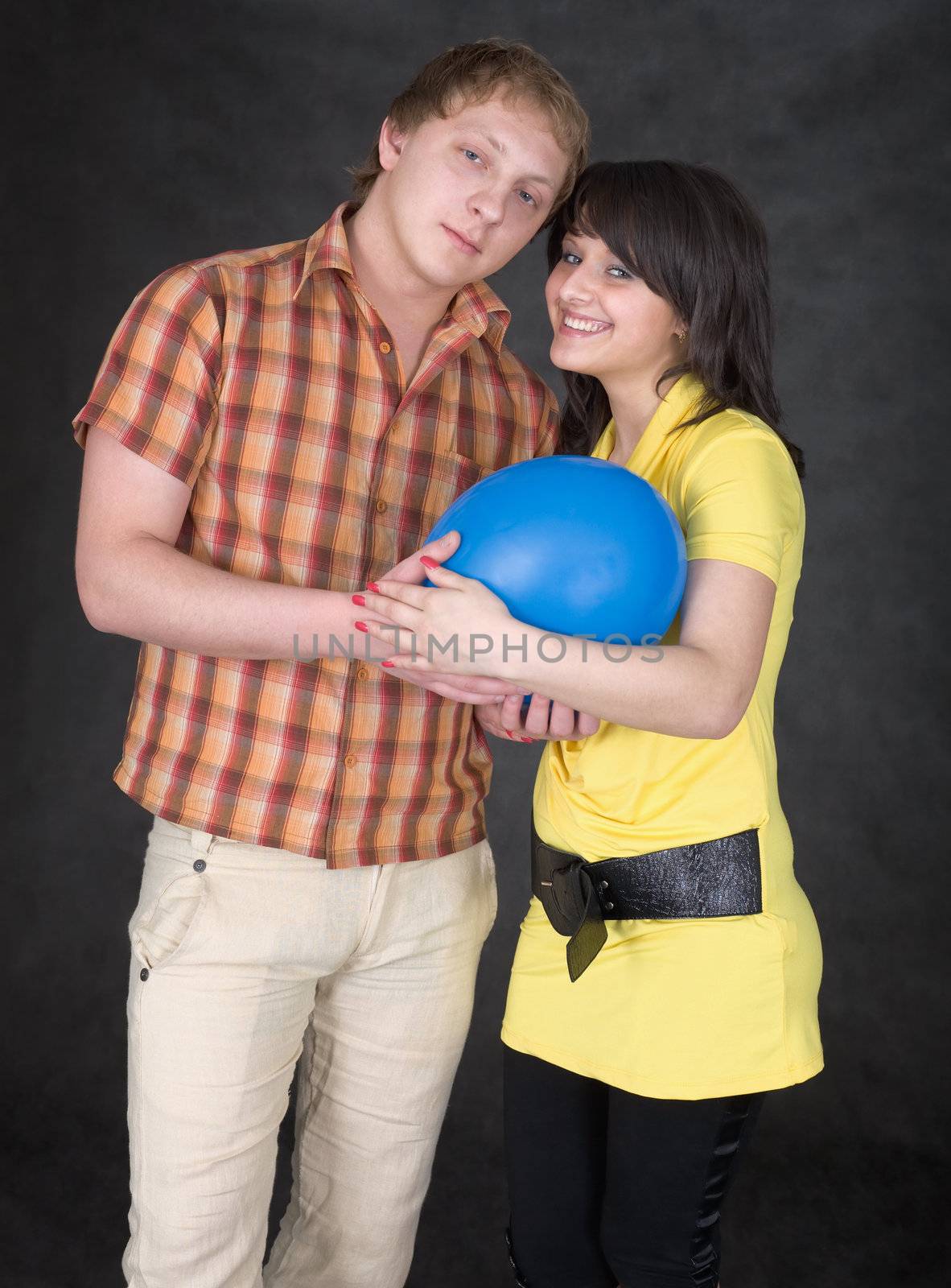 Pair of lovers and blue balloon on the black background
