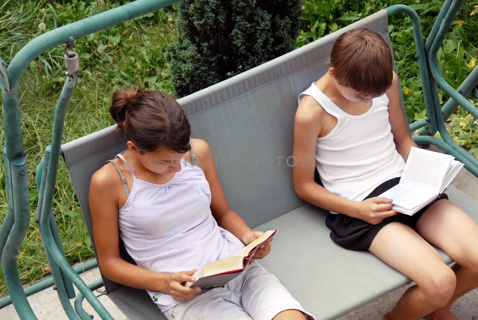 teen girl and boy reading books in yard outdoor