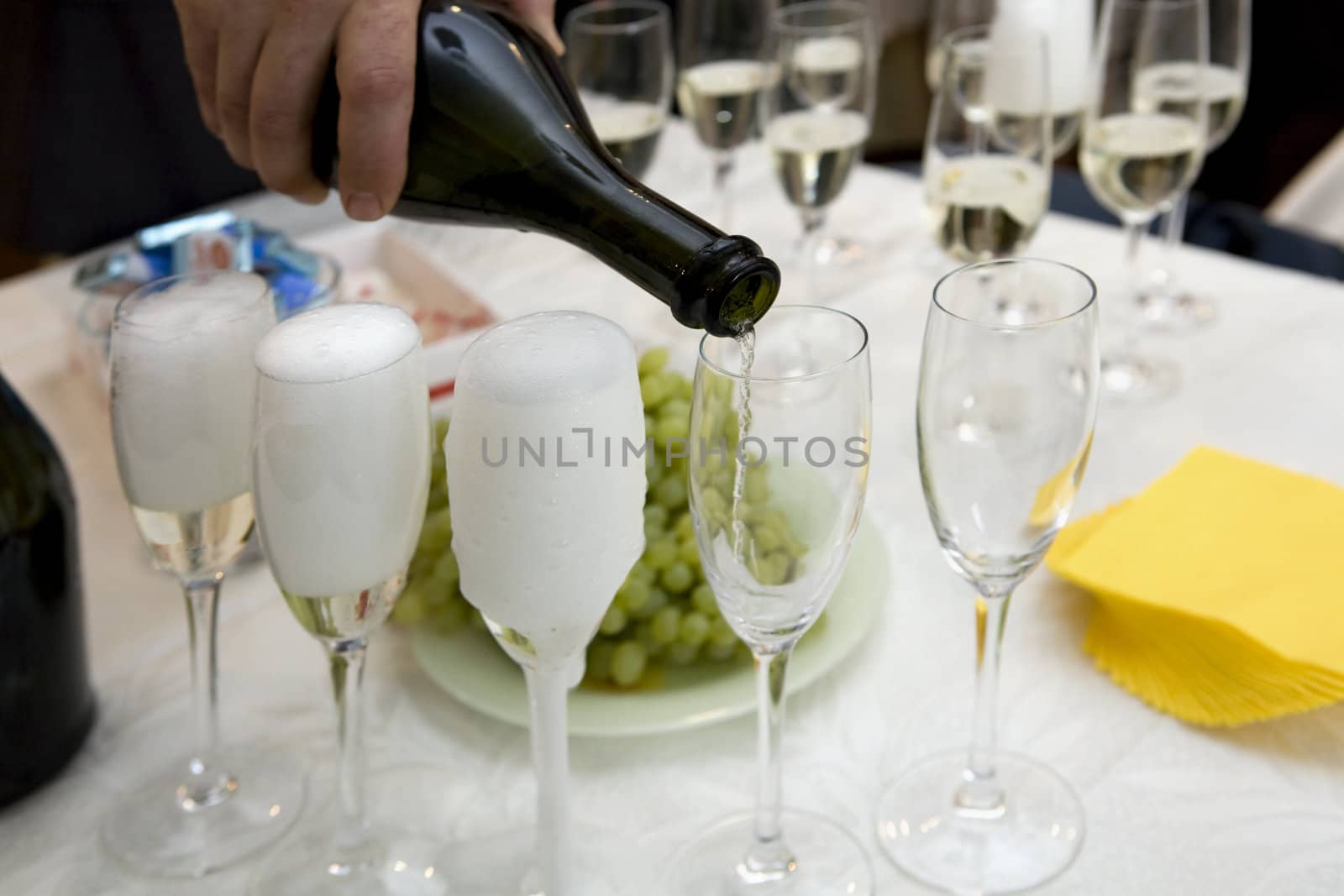 hand`s man pour out champagne in glasses. Wedding party