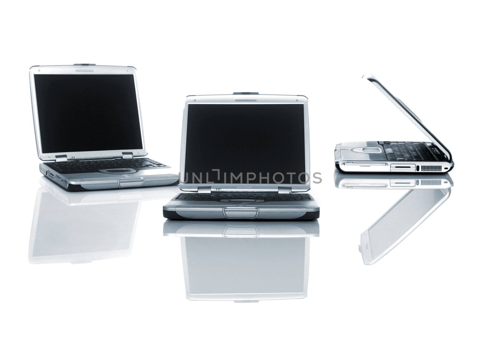 3 Silver Laptops over a table with reflection