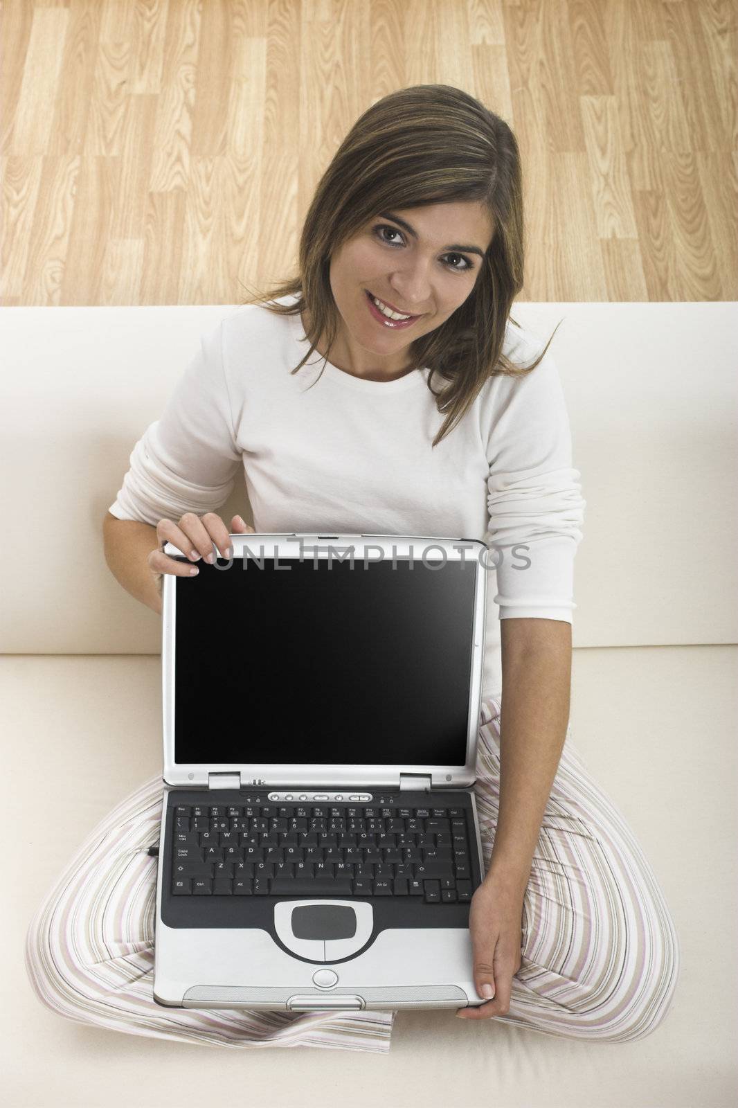 Beautiful woman working at home with her laptop and showing something to you
