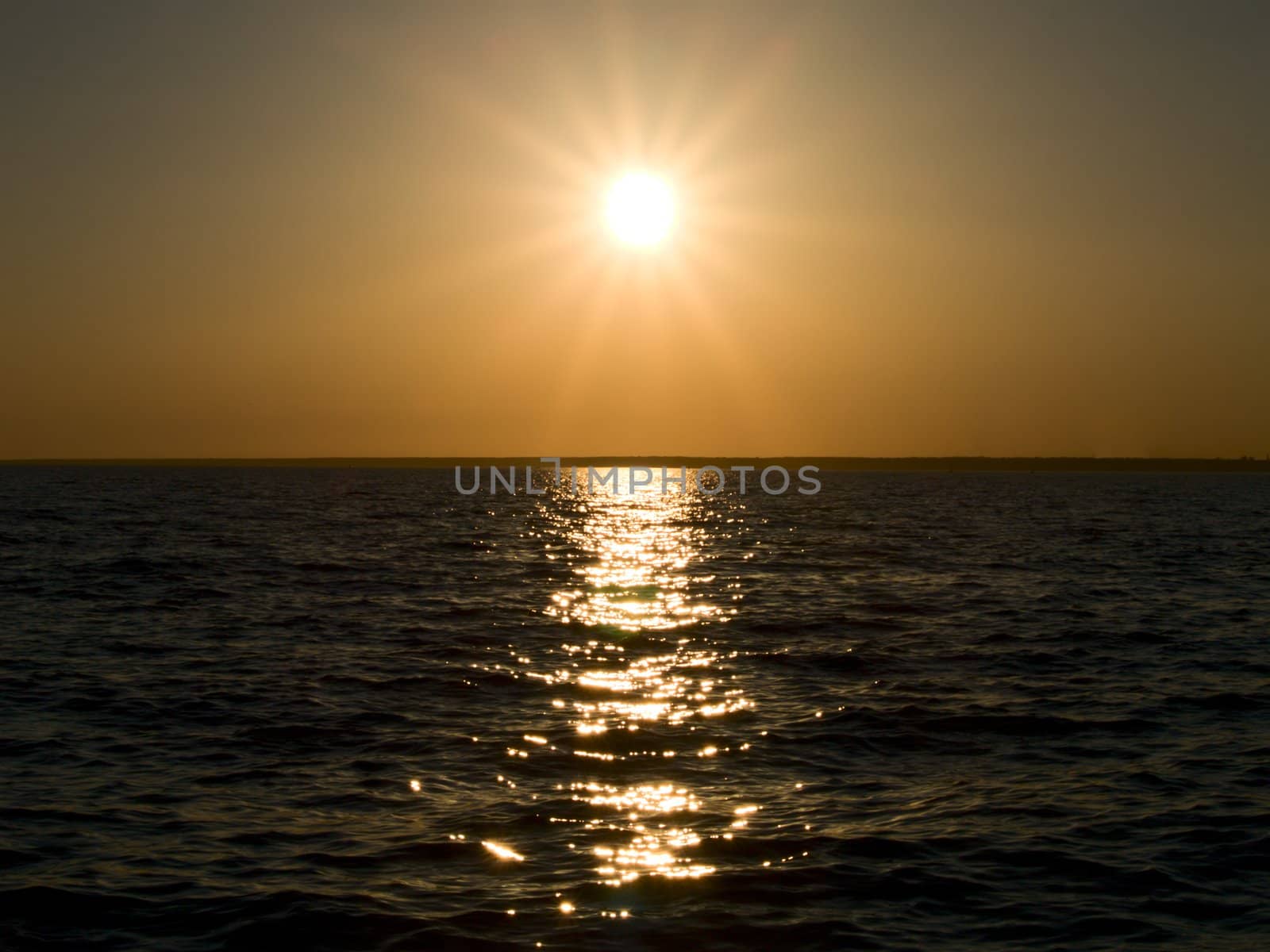 Sunset on a sea, sun with visible rays