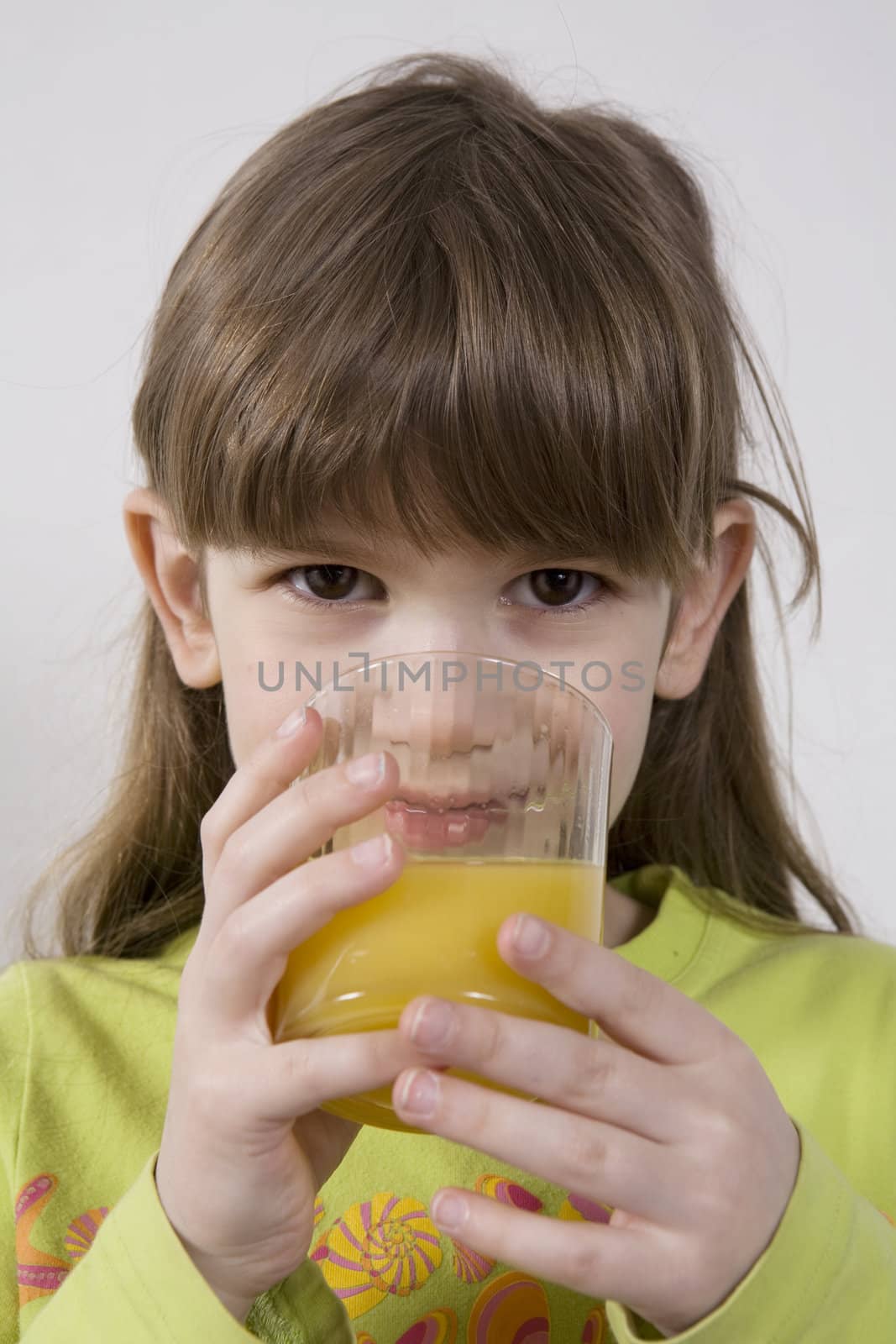 little cute adorable girl seven years old drink orange juice by elenarostunova