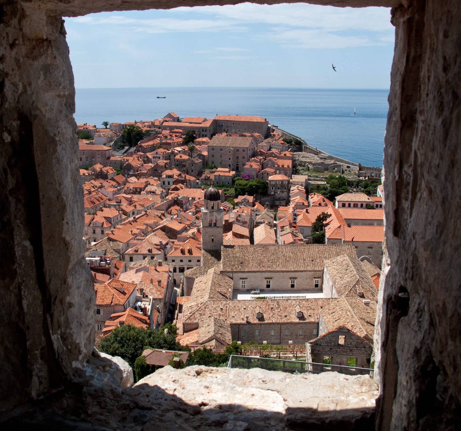 View over rooftops of Dubrovnik to tower and distant ocean