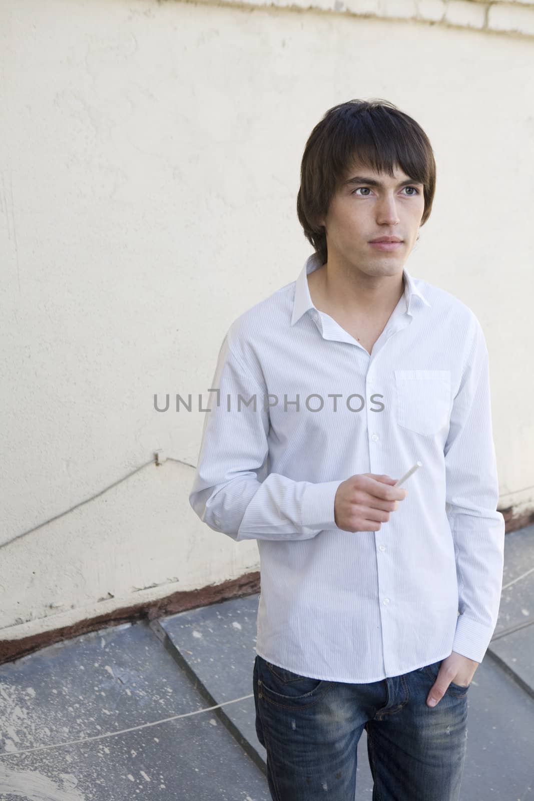 close up portrait of young serious handsome smoking man with cigarette