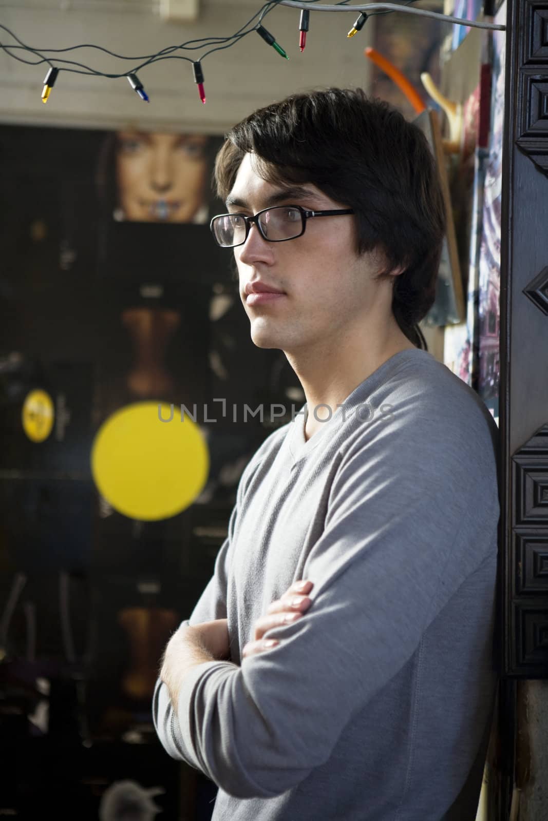 young handsome man wearing glasses rest against wall