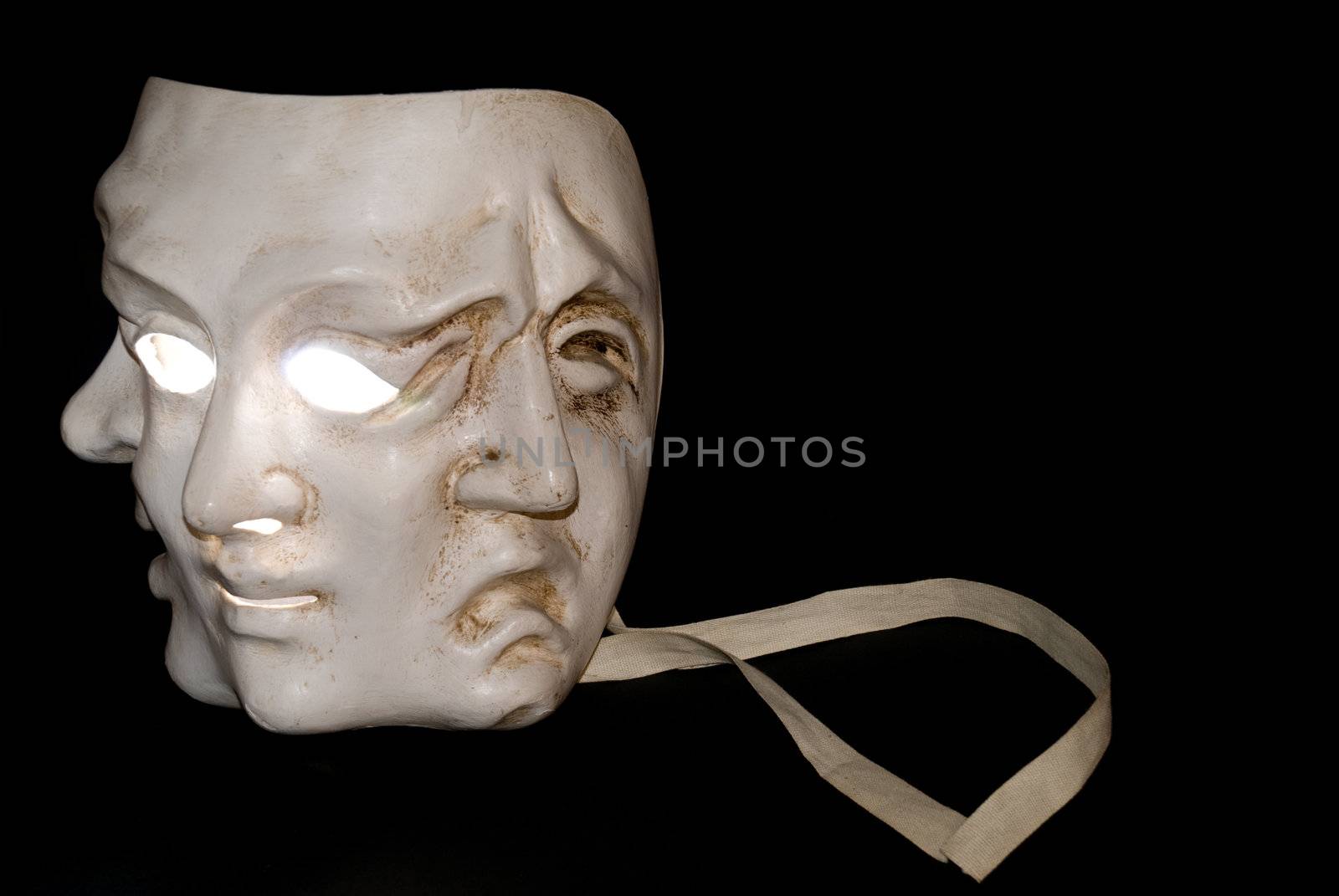 A mask with three faces showing three states of mind