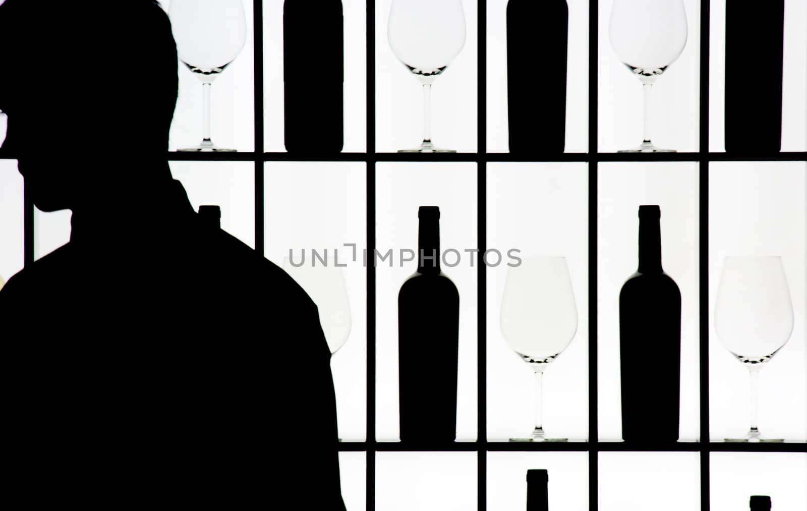 Silouette of a waiter against bottle and glasses