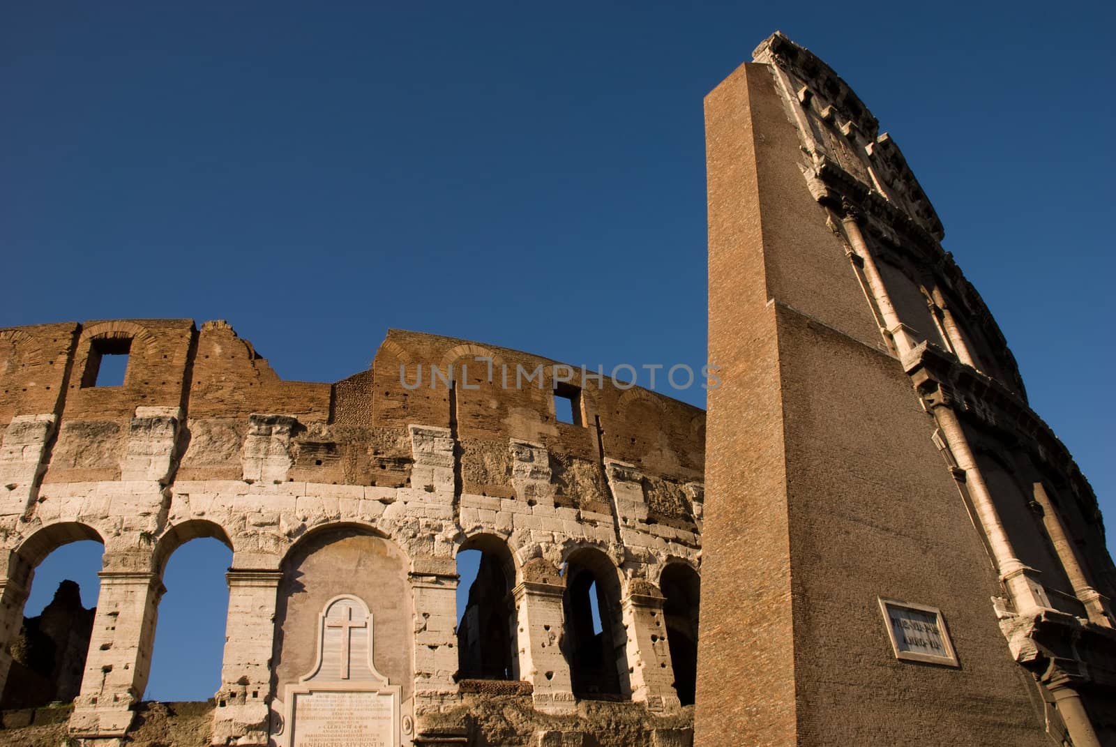 Low Angle view of the Colosseum Amphitheater in Rome against blue sky background.