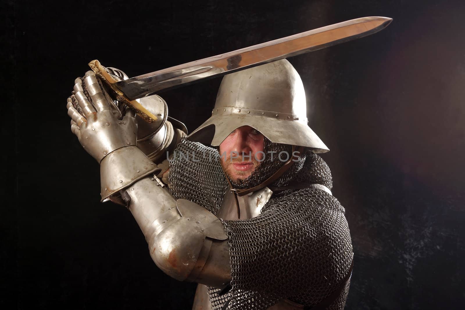 The soldier in a medieval knightly armour with we throw in hands