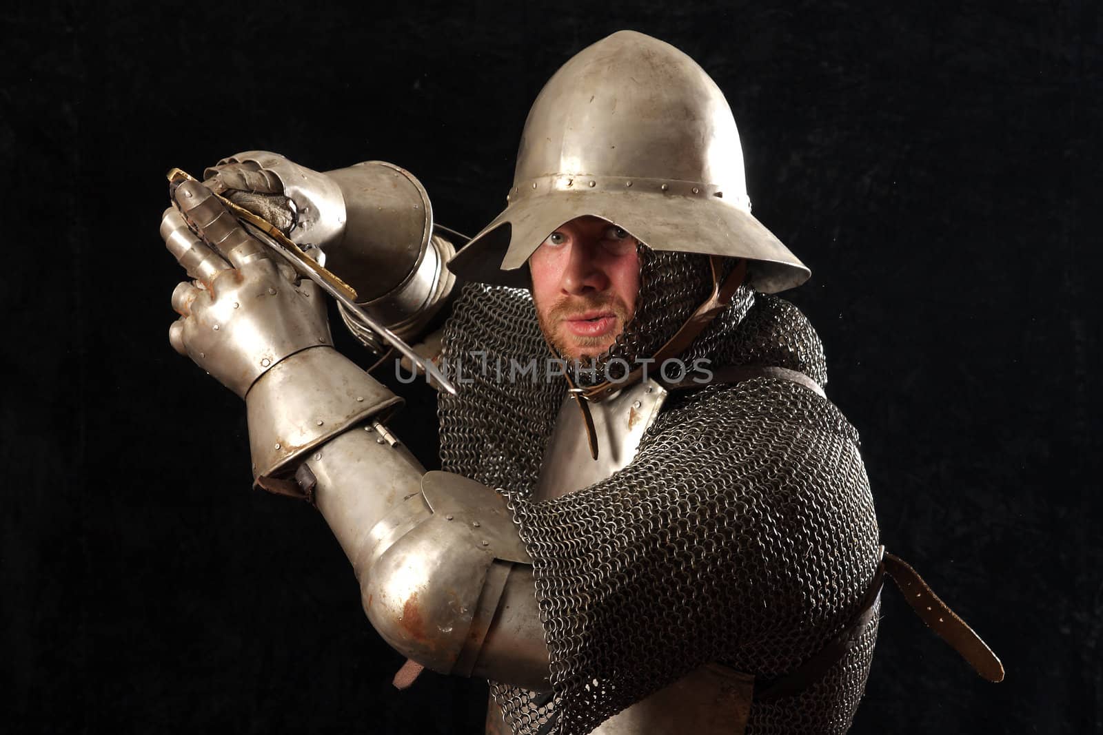 The soldier in a medieval knightly armour with we throw in hands