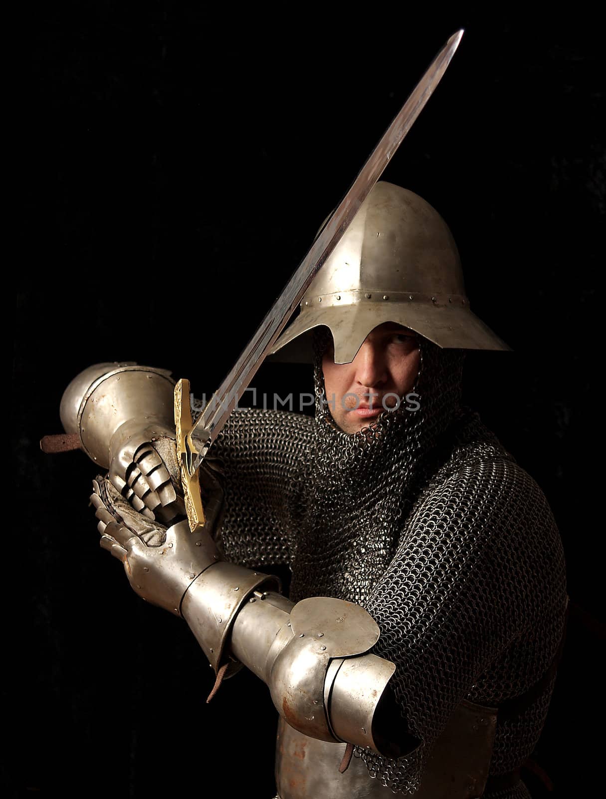 The soldier in a medieval knightly armour with we throw in hands