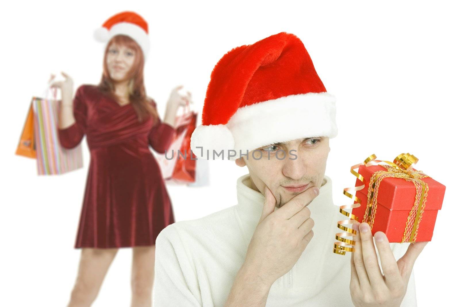 The young man in Christmas cap and the girl with purchases on background