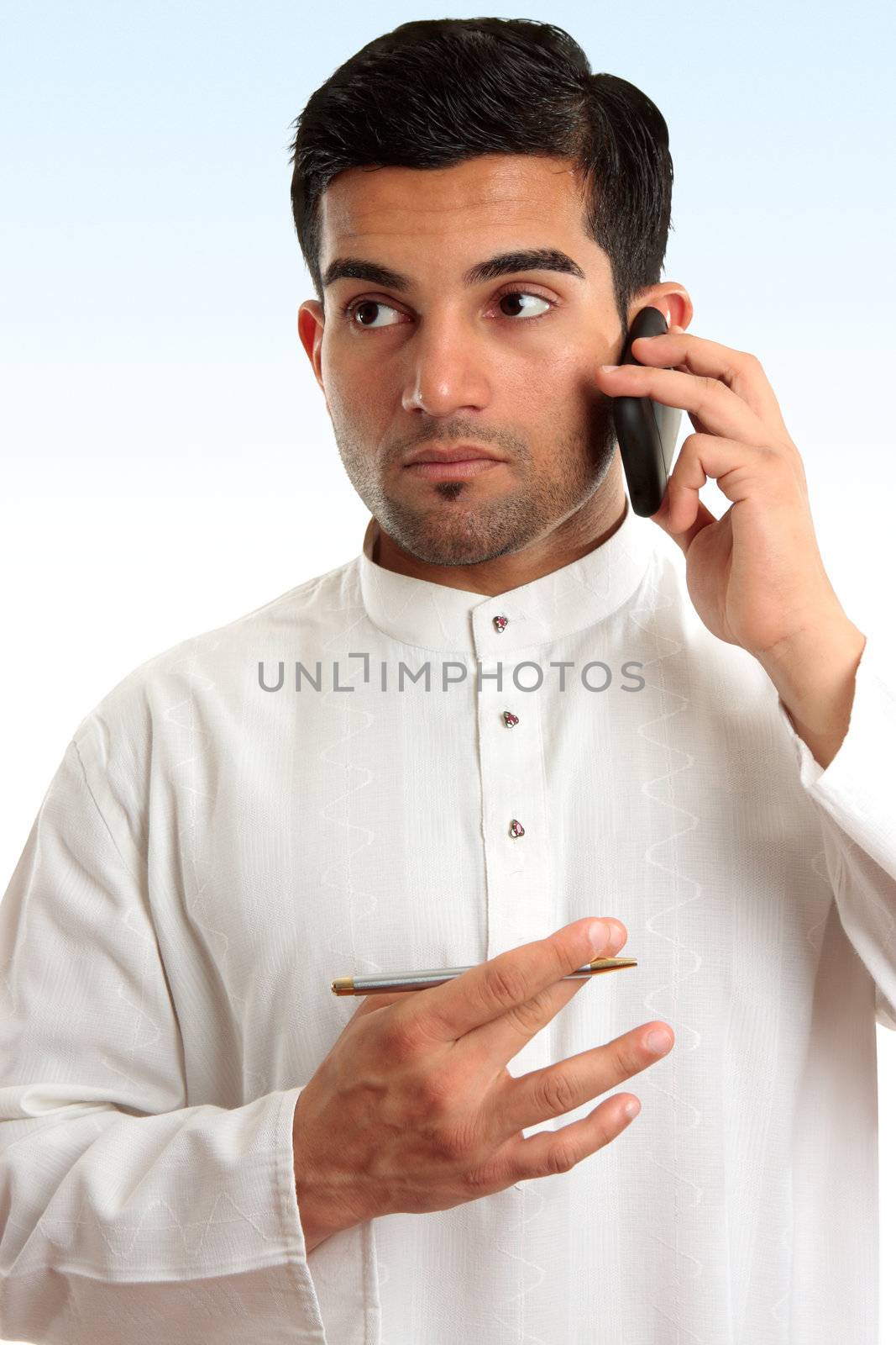 Ethnic mixed race businessman wearing traditional robe is using a mobile phone and looking sideways.