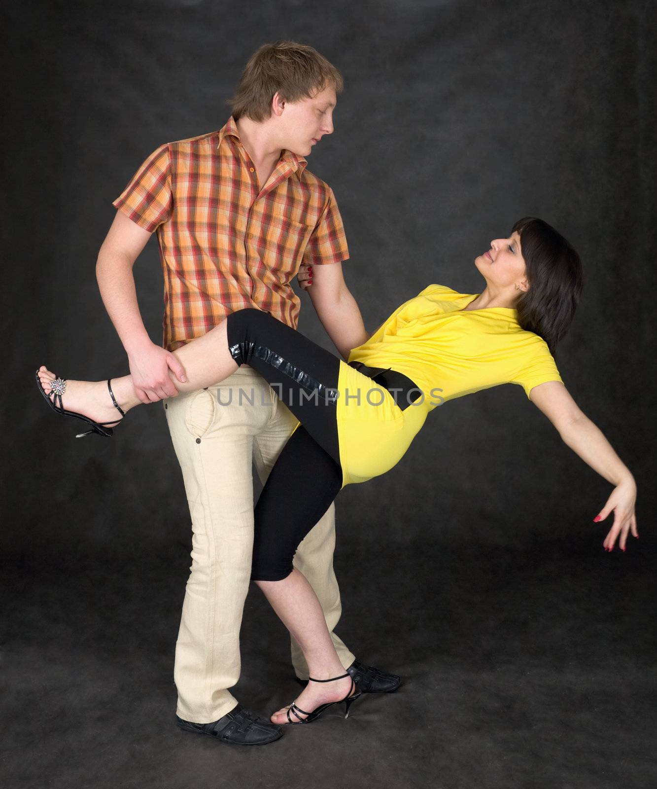 Couple dancing a tango on a black background