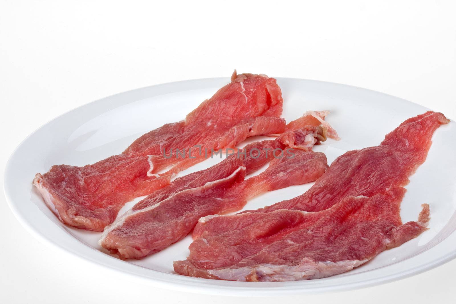 raw veal escalope isolated on white background by bernjuer